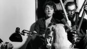 Retrato de 4 personas mirando a la cámara y un perro de espaldas mirándole a ellos