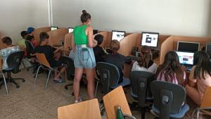 Profesora enseñando a niños ya dolescentes a usar ordenadores