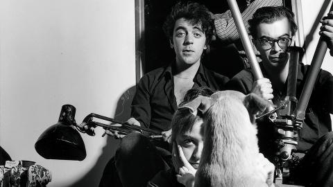 Retrato de 4 personas mirando a la cámara y un perro de espaldas mirándole a ellos