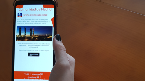 Banner de la App Tarjeta de Discapacidad Imagen de una mano que sujeta un móvil con la App "Tarjeta de discapacidad" y logotipo de la aplicación