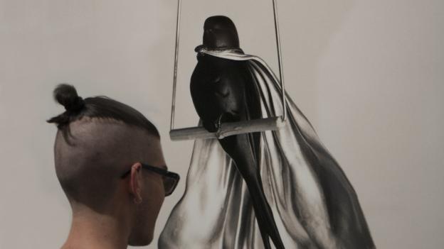 Exposicíon Chema Madoz Joven mirando una fotografía de un pájaro