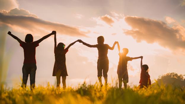 contraluz de niños agarrados de la mano