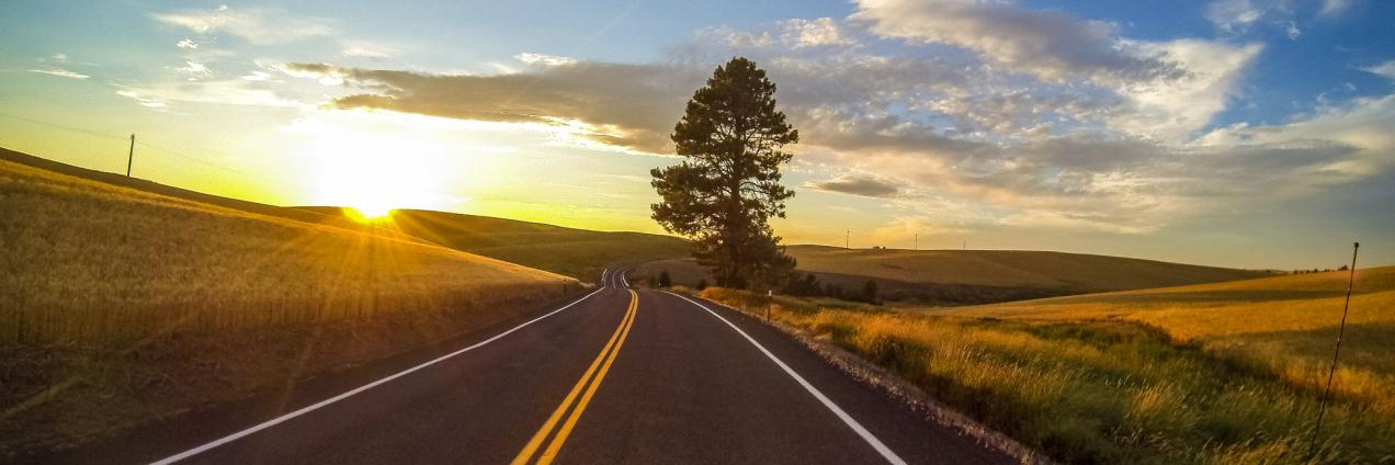 Carretera con puesta de sol al fondo