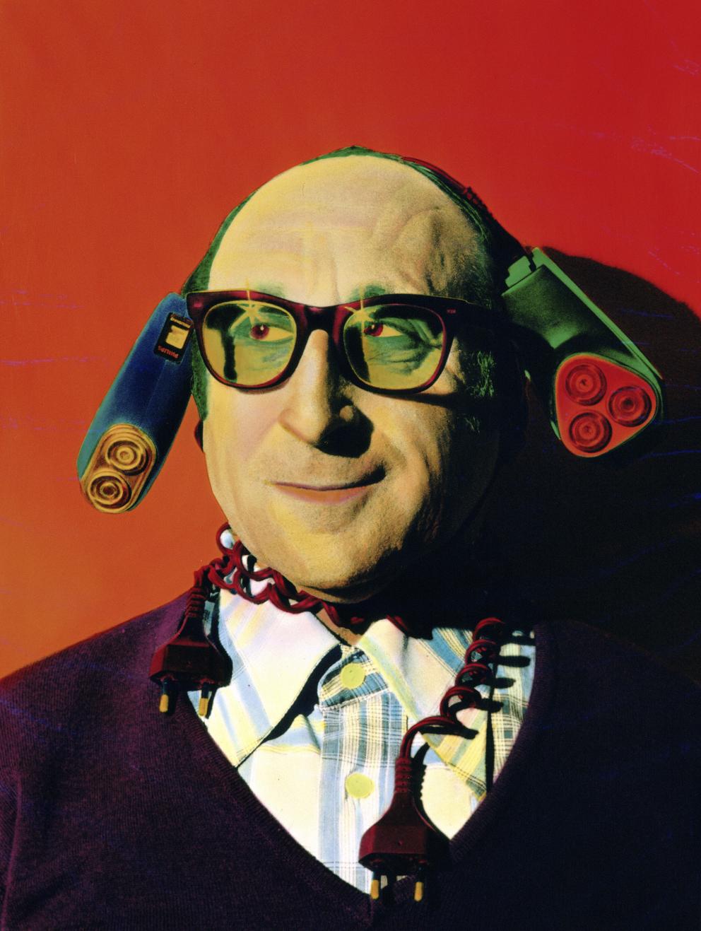 Retrato de un hombre con gafas y dos maquinas eléctricas de afeitar en la cabeza