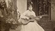 Una joven sentada en un patio tocando la guitarra