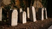 Lápidas sencillas frente a la pared de un cementerio