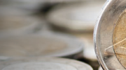Fotografía de monedas de euro con una de ellas en primer plano