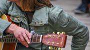 Mujer con la mano puesta en una guitarra