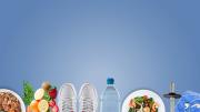 Plato con cereales, frutas, zapatillas de deporte, botella de agua, mancuernas, bol de ensalada y una toalla con auriculares  