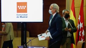 Ruíz Escudero ante la mesa de la rueda de prensa con cartel detrás de la Comunidad de Madrid