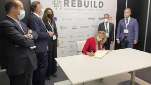 La consejera firmando el libro de visitas del evento