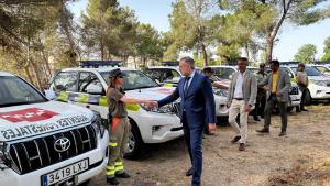 El consejero Enrique López saluda a agentes forestales en el lugar donde están los nuevo vehículos