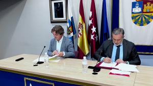 El consejero Enrique López sentado firmando el acuerdo