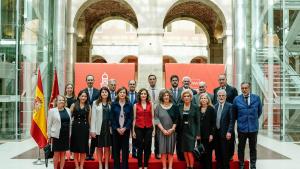 La presidenta, el consejero Enrique López y los representantes del comité se hacen una foto en la Real Casa de Correos