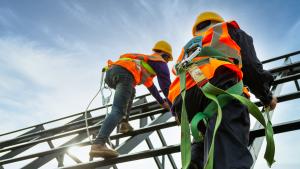 Dos trabajadores con su correspondiente equipo de protección subidos a un andamio