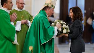 La presidenta entregando las flores al sacerdote