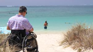 imagen de hombre en silla de ruedas en la playa