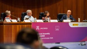 Cuatro personas sentadas en una mesa principal en una reunión