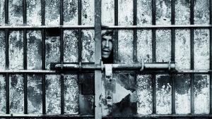 Marisa Flórez. Motines en la cárcel de Carabanchel. Madrid, 1977 y 1981. © Marisa Flórez, 2026 Rostro de un hombre asomando por el hueco de una puerta