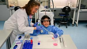 Una niña hace un experimento junto a una investigadora