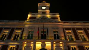 Fachada iluminada de la Real Casa de Correos en la Puerta del Sol de noche