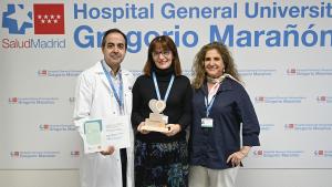 Tres personas posando con un premio para una foto