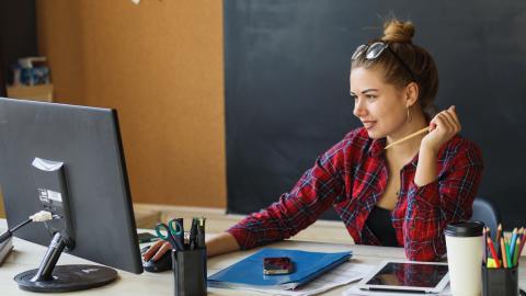 Mujer buscando en un ordenador centros educativos.