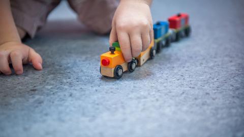 Bebé jugando con tren de madera