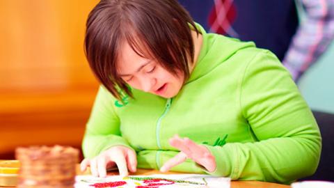 Joven con discapacidad intelectual realiza un trabajo de artesanía