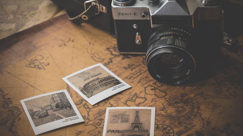 Se observa una imagen en tres planos. el primer plano es un mapa, el segundo plano son tres fotos polaroid de París, Roma y Londres. y el último plan