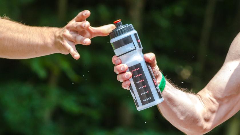 deportistas pasándose botella de agua
