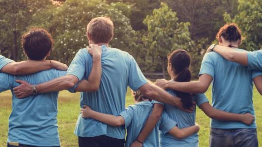 Voluntarios de espaldas abrazados