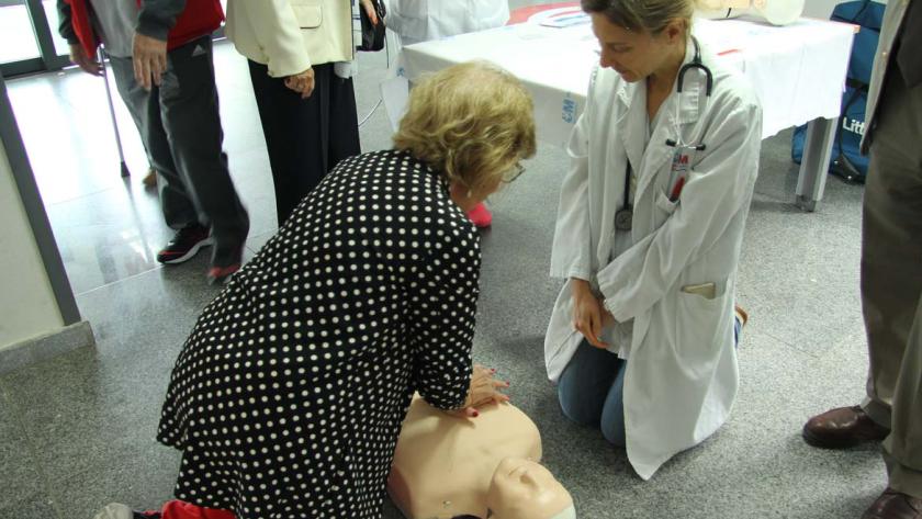 Una mujer realiza maniobras de resucitación cobre un maniquí