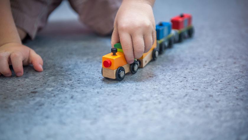 Bebé jugando con tren de madera