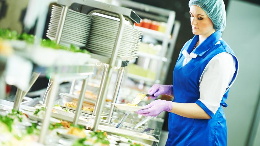 Una mujer sirviendo comida en un comedor