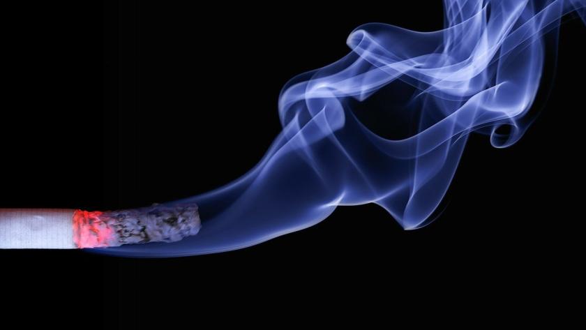 Humo de un cigarro encendido sobre fondo negro