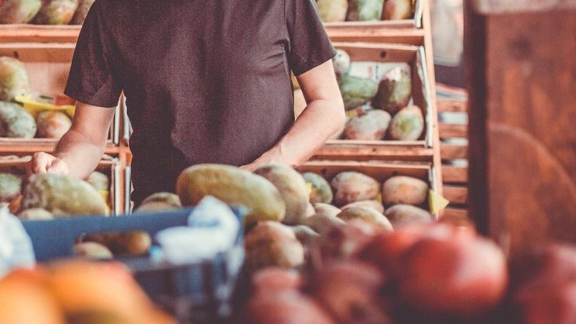 Un hombre coge frutas en una tienda