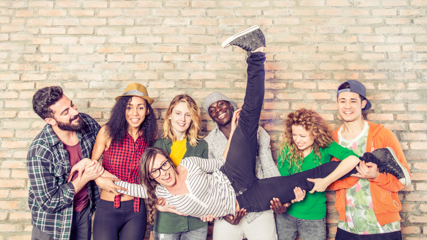Jóvenes sujetando a otro con la pierna hacia arriba