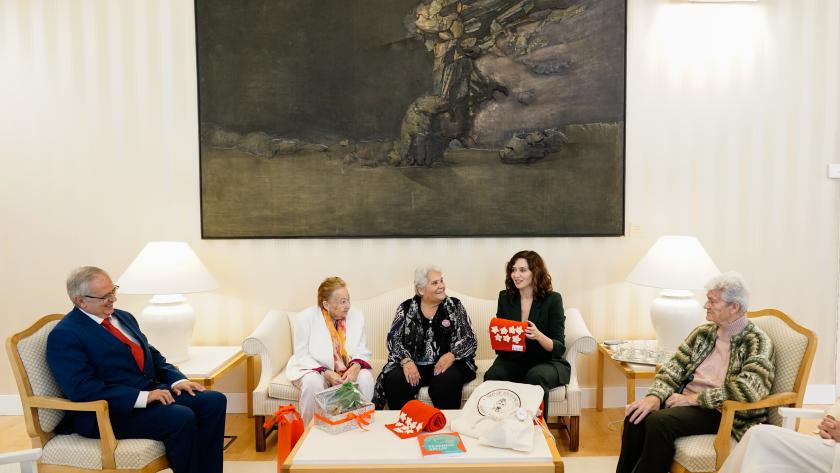 La presidenta ha conocido las experiencias de mujeres que le han obsequiado con una bufanda de los colores de la bandera madrileña