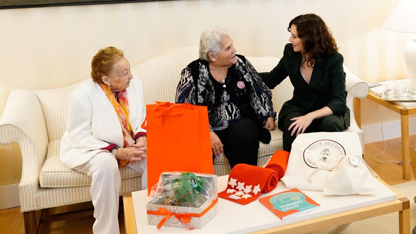 La presidenta ha conocido las experiencias de mujeres que le han obsequiado con una bufanda de los colores de la bandera madrileña