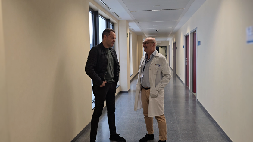 Médico y paciente hablando en pasillo de consultas