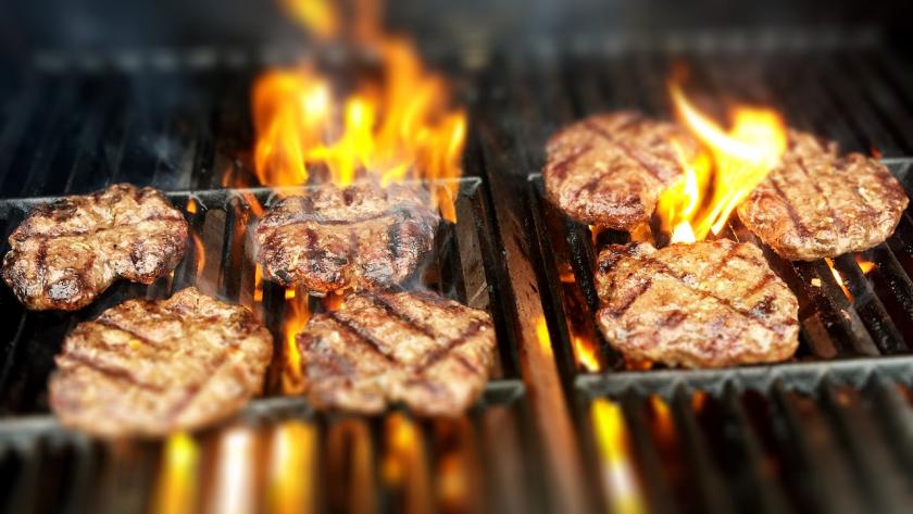 Hamburguesas en la parrilla con fuego vivo