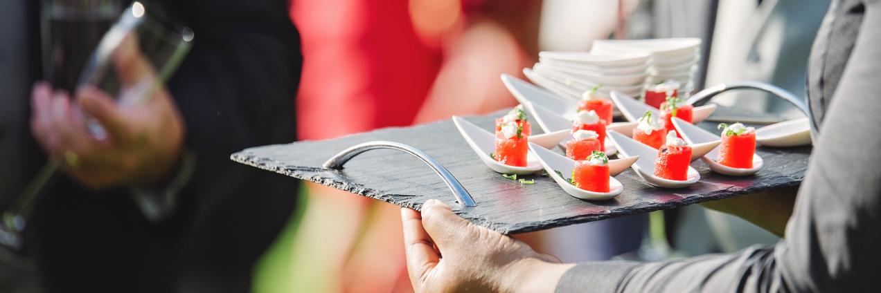 Camarero sirviendo canapés en evento al aire libre