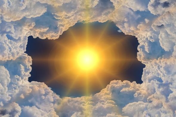 Sol radiante amarillo entre nubes