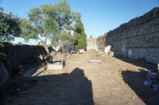 Imagen de recinto amurallado con árboles y restos de tumbas durante su intervención arqueológica