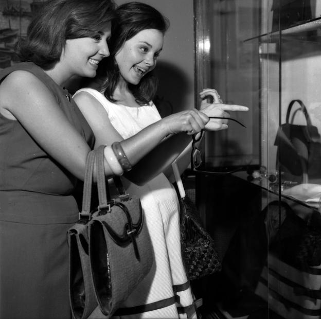 imagen de dos mujeres en una boutique señalando un bolso