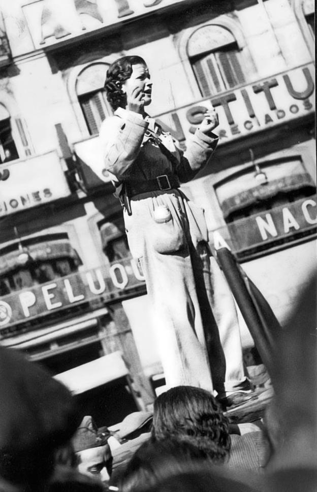 imagen de mujer subida a una plataforma dando un discurso en la calle