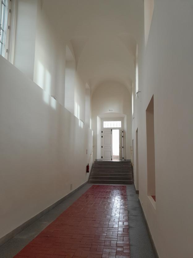 imagen de galería con ventanales y puerta al fondo