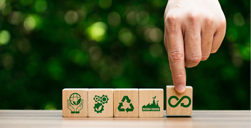 mano colocando piezas con símbolos de economía circular