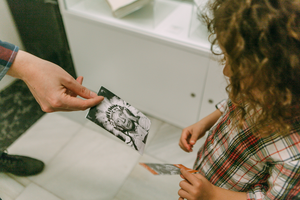 Visitas mediadas en MPCEA. Foto Guillermo Gumiel Una mano sostiene una foto de un hombre que muestra a una niña